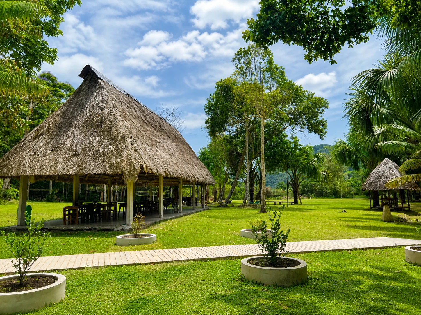 Choza de comedor al aire libre rodeada por los jardines de El Nativo